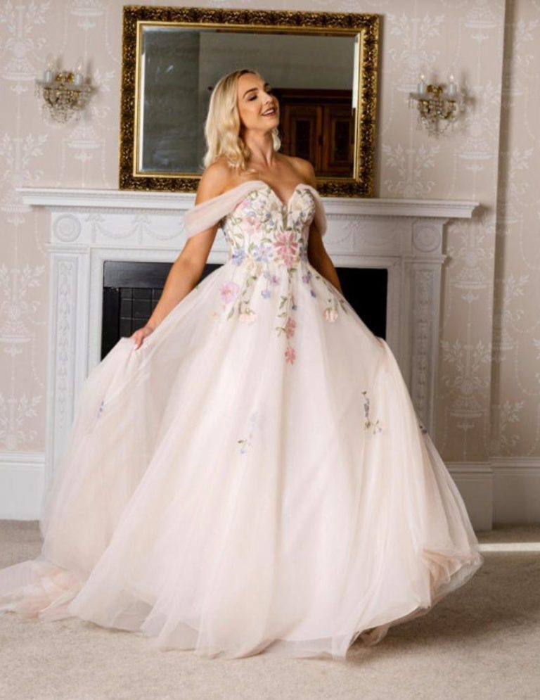 Princess Dress A woman in a pink, floral-embroidered ball gown poses elegantly.