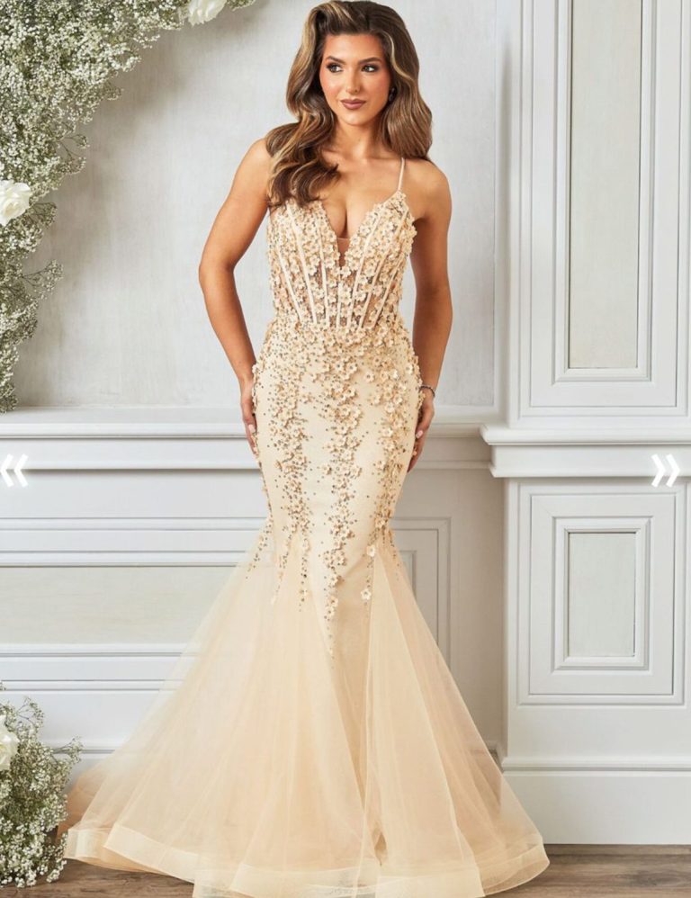 Fish Tail Dress Beaded A woman in a fitted, beaded gown with a mermaid silhouette and sheer skirt.
